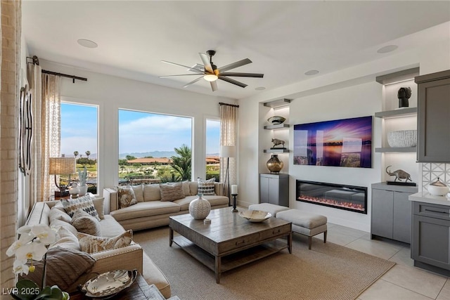 living room featuring light tile patterned floors, ceiling fan, and a healthy amount of sunlight