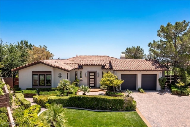 mediterranean / spanish-style house featuring a front lawn and a garage