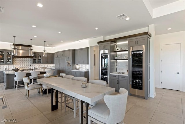 tiled dining room featuring beverage cooler and sink