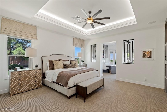 carpeted bedroom featuring ceiling fan, a raised ceiling, and connected bathroom