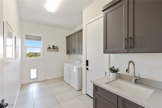 washroom featuring cabinets, separate washer and dryer, sink, and light tile patterned floors