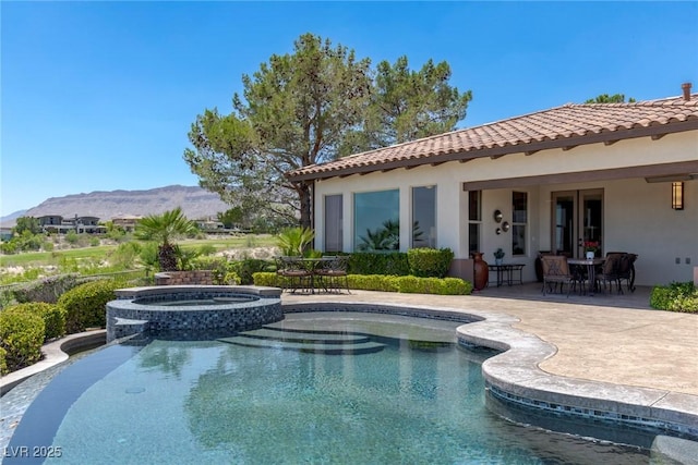 view of swimming pool with a mountain view, an in ground hot tub, and a patio