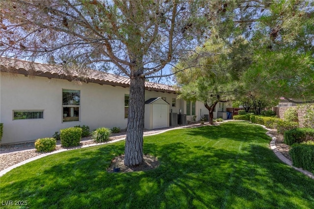 view of side of property featuring a lawn and a storage unit