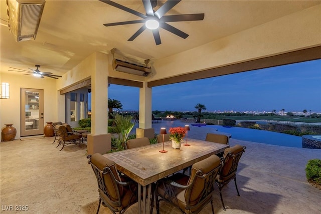 patio terrace at dusk featuring a wall unit AC