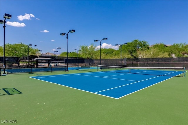 view of tennis court featuring basketball hoop