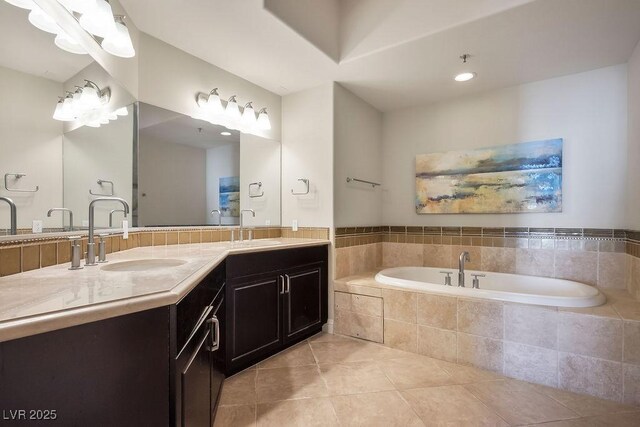 bathroom with tile patterned flooring, vanity, and a relaxing tiled tub