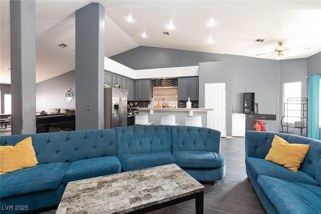 living room with dark wood-type flooring, ceiling fan, and high vaulted ceiling