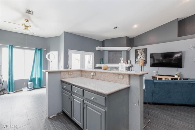 kitchen featuring gray cabinetry, a wealth of natural light, ceiling fan, and a kitchen island