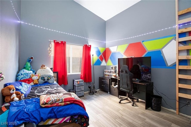 bedroom with lofted ceiling and hardwood / wood-style floors