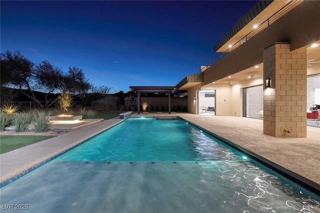 pool at twilight with a patio area