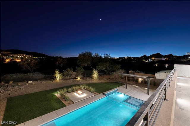 pool at twilight with a lawn and a patio