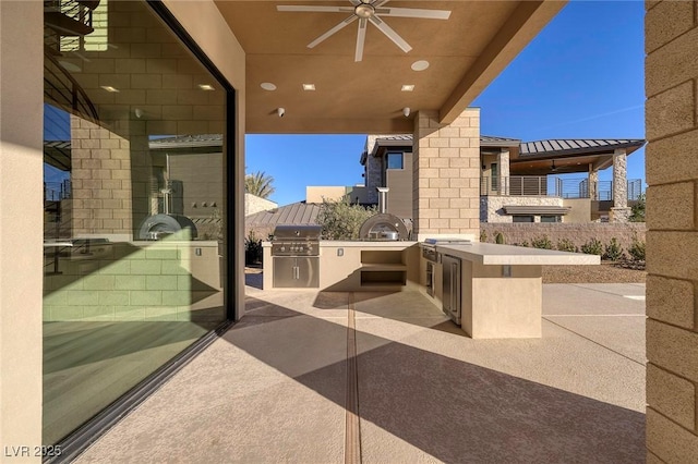 view of patio with an outdoor kitchen, ceiling fan, and grilling area