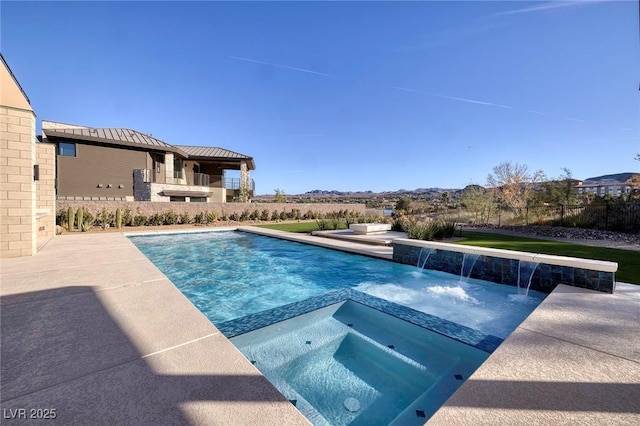 view of swimming pool featuring pool water feature, a patio area, and an in ground hot tub