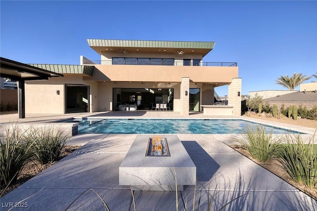 view of pool with a jacuzzi, a patio area, and an outdoor fire pit