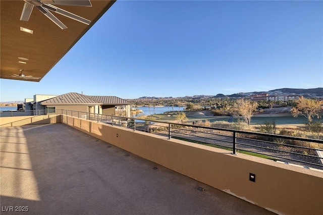 balcony featuring ceiling fan and a water and mountain view