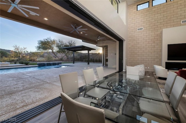 view of patio / terrace featuring pool water feature, ceiling fan, and a fenced in pool