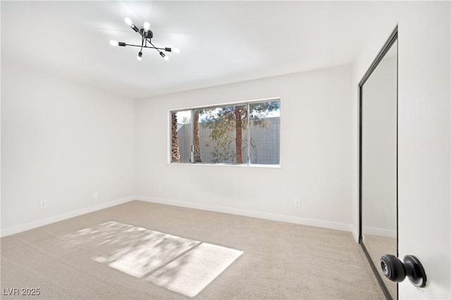 unfurnished bedroom featuring light colored carpet, an inviting chandelier, and a closet