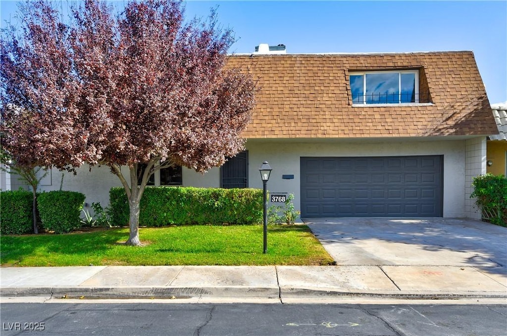 view of front of house featuring a garage and a front lawn