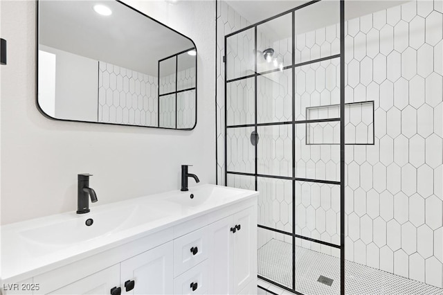 bathroom featuring a tile shower and vanity