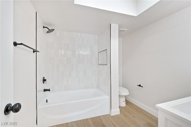 bathroom with hardwood / wood-style flooring, toilet, and bathtub / shower combination