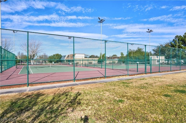 view of tennis court featuring a lawn