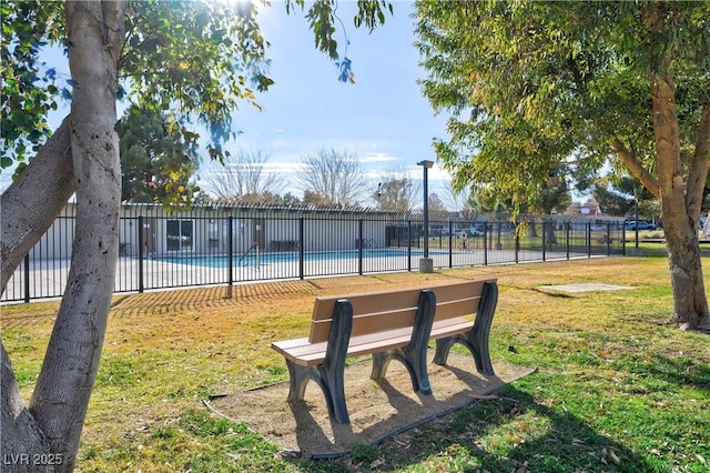 view of home's community with a pool and a lawn