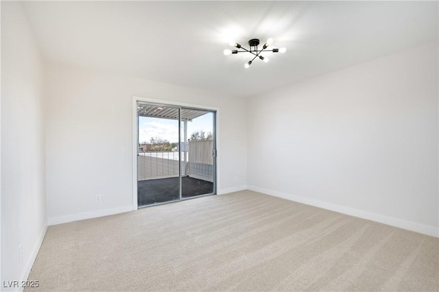 unfurnished room with carpet and a chandelier