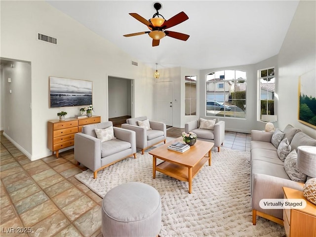 living room with ceiling fan, light tile patterned floors, and vaulted ceiling