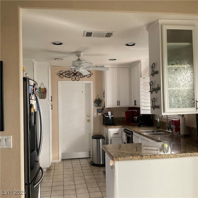 kitchen with kitchen peninsula, ceiling fan, white cabinets, stainless steel refrigerator, and light tile patterned flooring