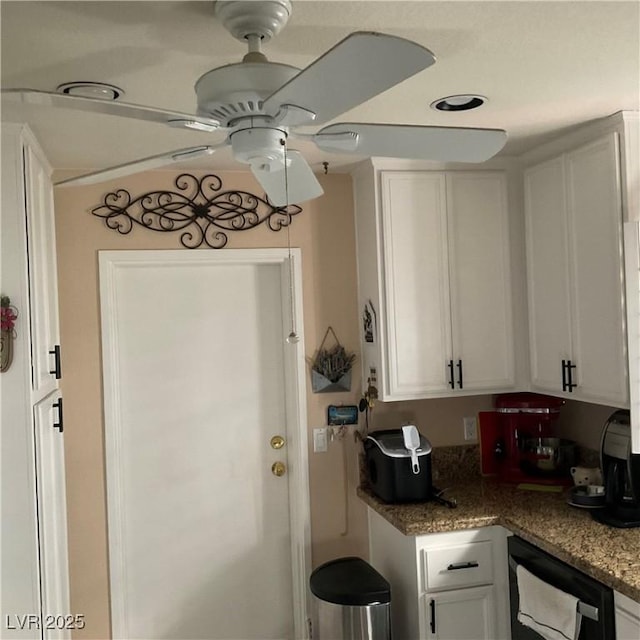 kitchen with dishwashing machine, ceiling fan, white cabinets, and dark stone counters