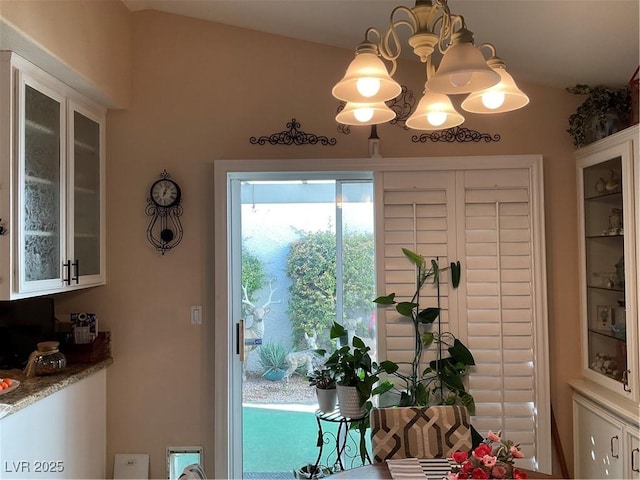 doorway to outside featuring a notable chandelier