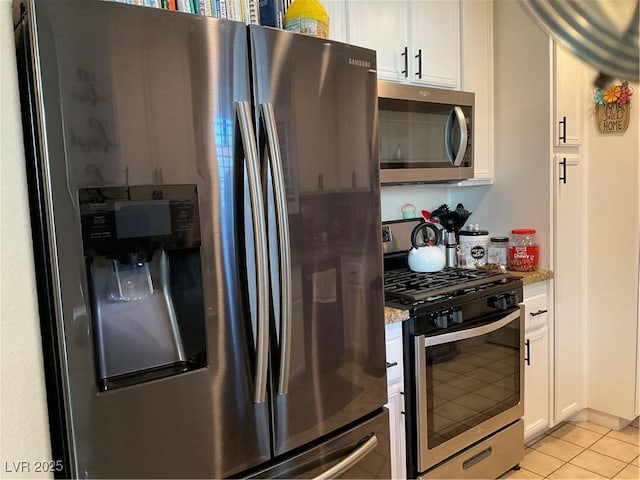 kitchen featuring white cabinetry, light tile patterned floors, stainless steel appliances, and light stone counters