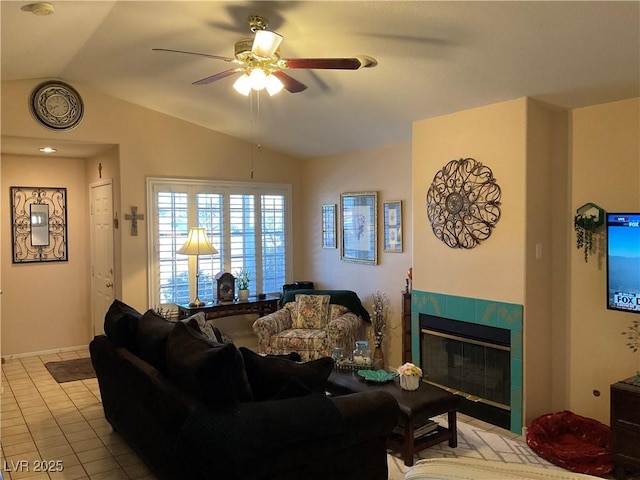 tiled living room featuring a tile fireplace, vaulted ceiling, and ceiling fan