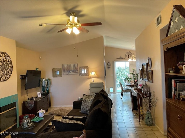 tiled living room featuring ceiling fan with notable chandelier and lofted ceiling