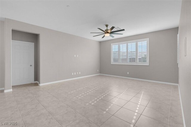 empty room featuring ceiling fan, light tile patterned floors, visible vents, and baseboards