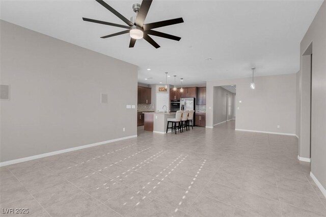 unfurnished living room with a ceiling fan, recessed lighting, and baseboards