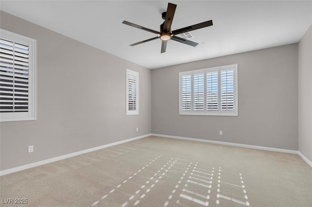 unfurnished room featuring a ceiling fan, light colored carpet, visible vents, and baseboards