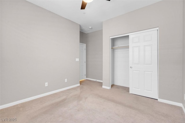 unfurnished bedroom with baseboards, ceiling fan, a closet, and light colored carpet