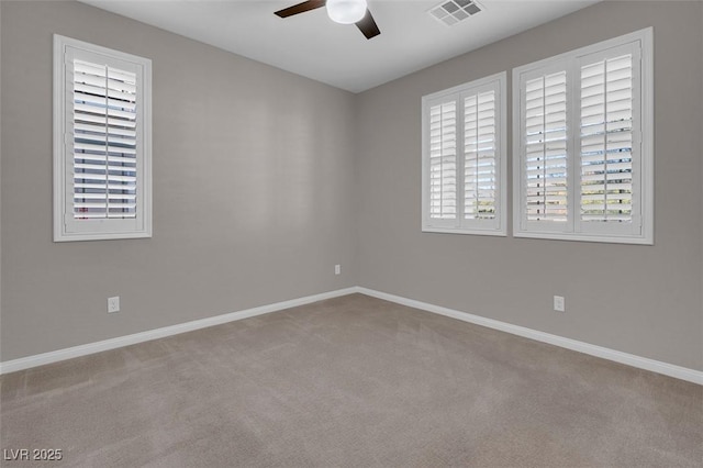 unfurnished room with visible vents, ceiling fan, light carpet, and baseboards