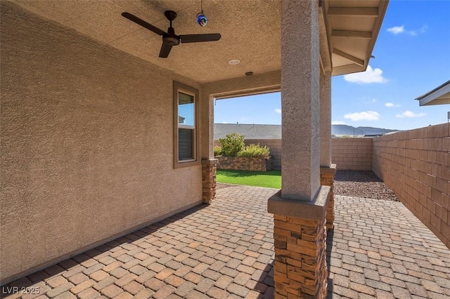 view of patio featuring a water view, a fenced backyard, and ceiling fan