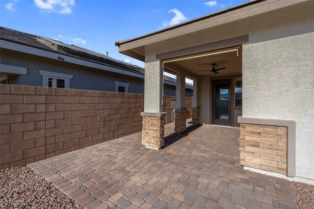 view of patio / terrace with fence and a ceiling fan