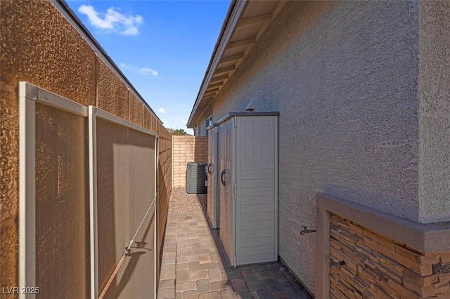 view of side of home with fence and stucco siding