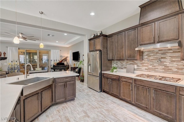 kitchen with ceiling fan, hanging light fixtures, decorative backsplash, dark brown cabinets, and appliances with stainless steel finishes