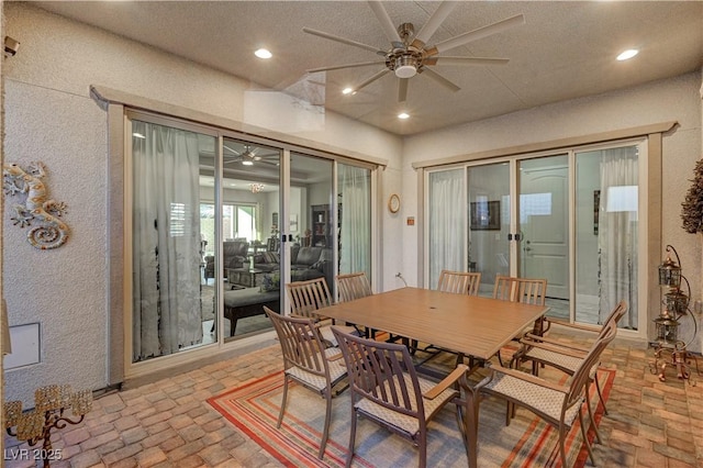 dining area featuring ceiling fan and a textured ceiling