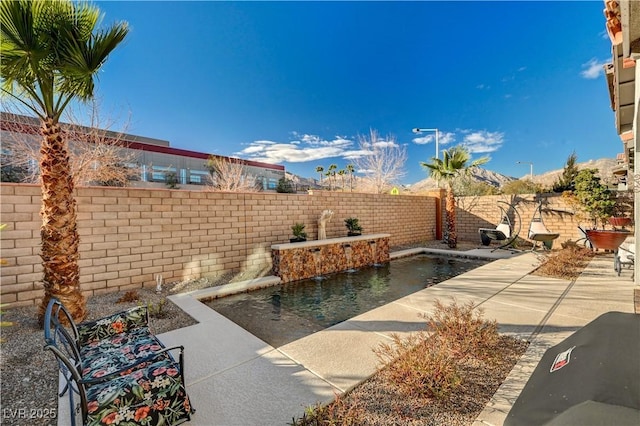 view of patio featuring pool water feature and a fenced in pool