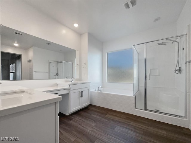 bathroom featuring plus walk in shower, wood-type flooring, and vanity