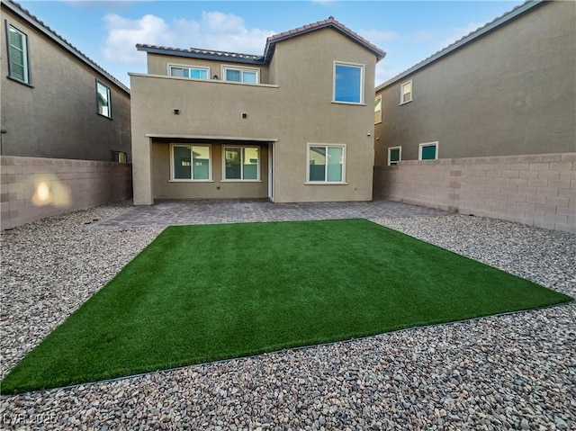 back of property featuring a lawn and a patio