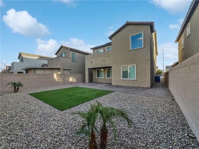 back of house featuring a lawn and a patio