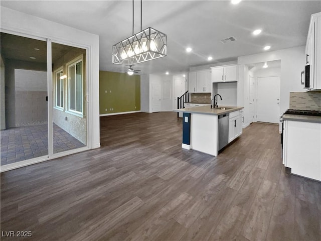 kitchen with white cabinets, a center island with sink, stainless steel dishwasher, and hanging light fixtures