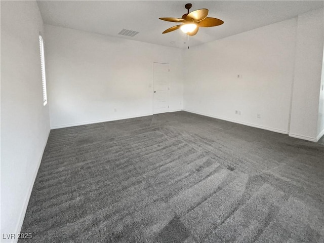 empty room featuring dark colored carpet and ceiling fan